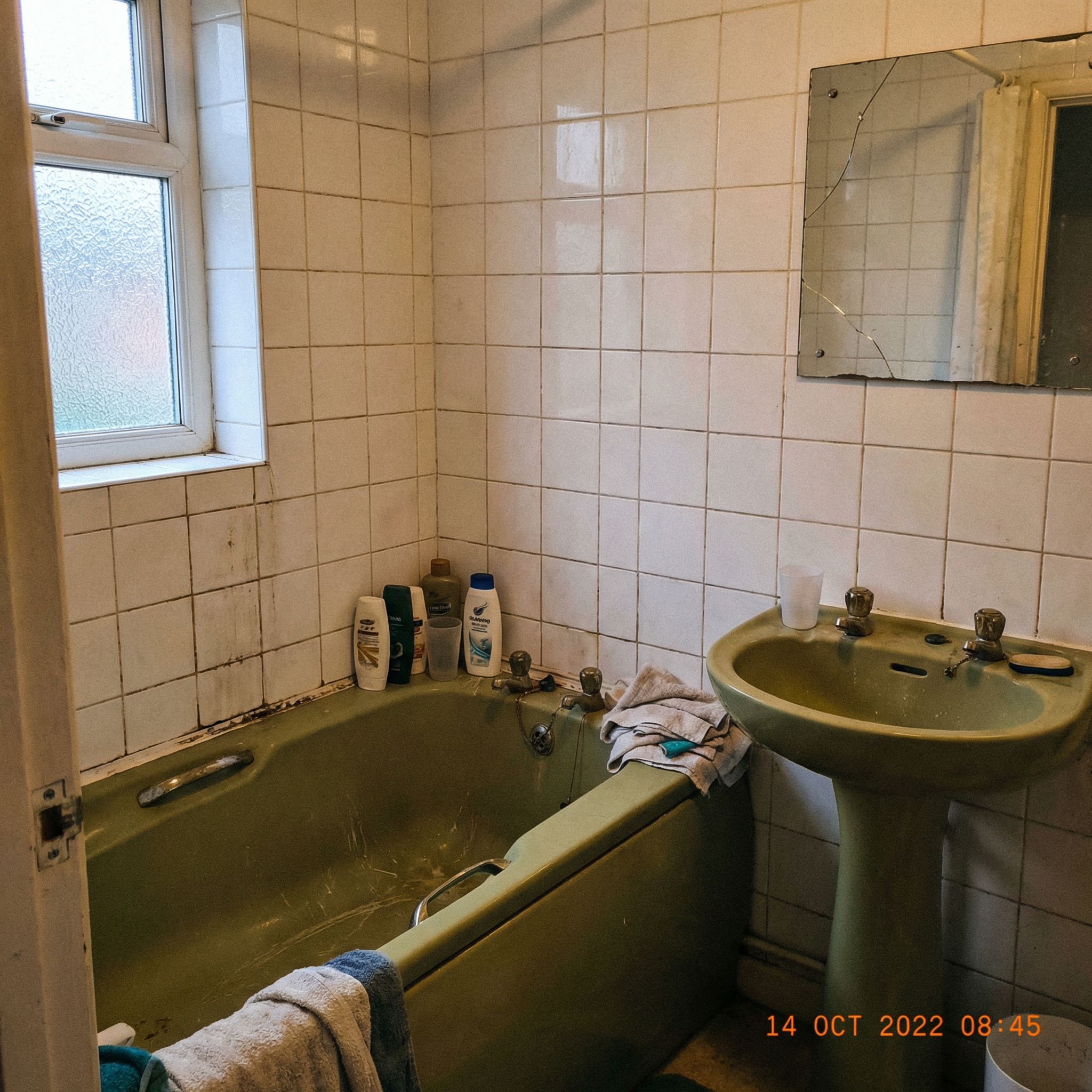 Bathroom before renovation - dated fixtures and tiles